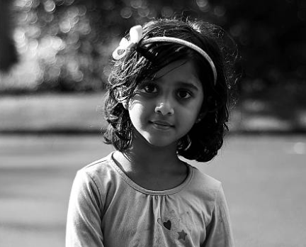 A black and white photo of a young Indian girl. The image encourages sign-ups for the Veer App's early access in Rajajinagar, Bengaluru.